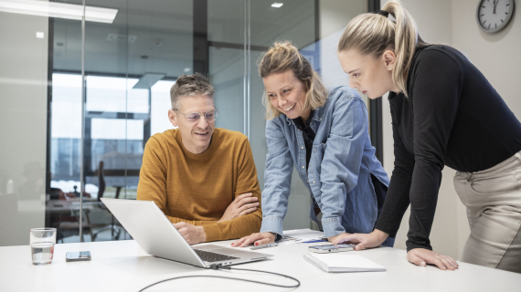 Employees together looking on plans on a desk
